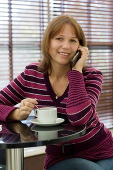 Girl Talks By A Mobile Phone Royalty Free Stock Photos