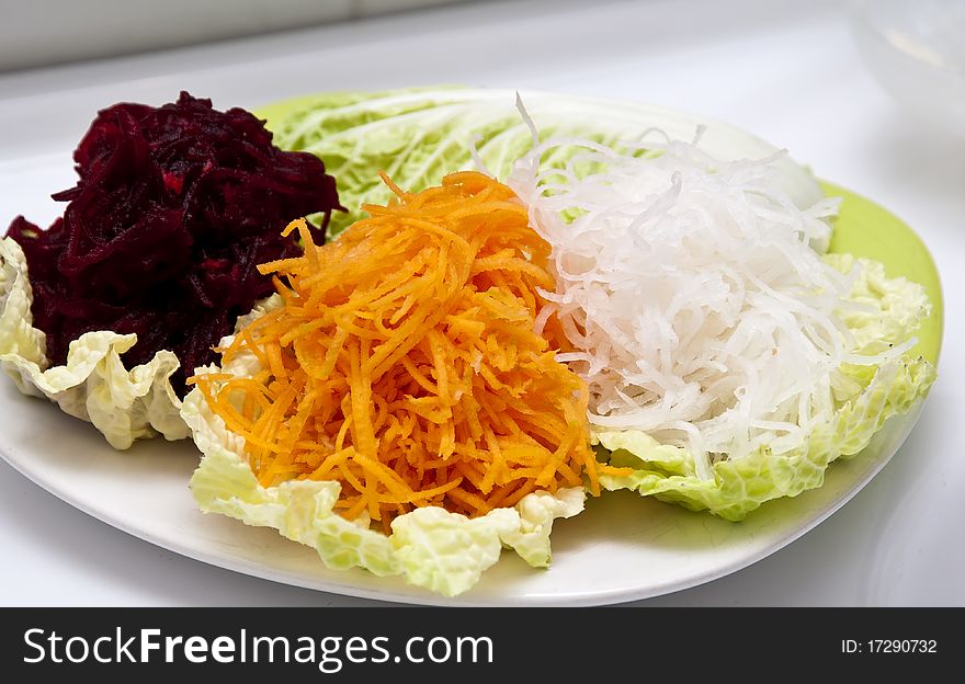 Boiled grated beets, carrot and redish daikon on a piece of lettuce. Boiled grated beets, carrot and redish daikon on a piece of lettuce