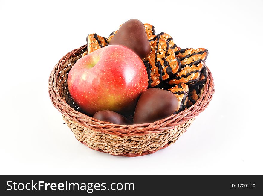 Sweet cookies and ripe apple in the wicker plate. Sweet cookies and ripe apple in the wicker plate