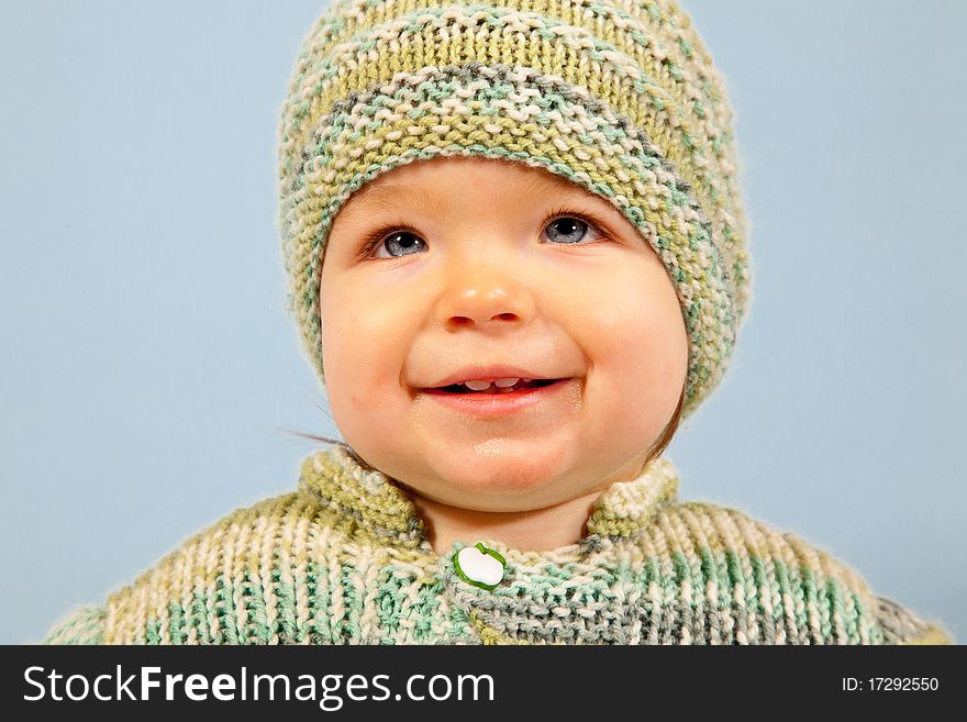 A smiling young Boy in Winter, isolated in Studio with Baby-Blue Background. A smiling young Boy in Winter, isolated in Studio with Baby-Blue Background