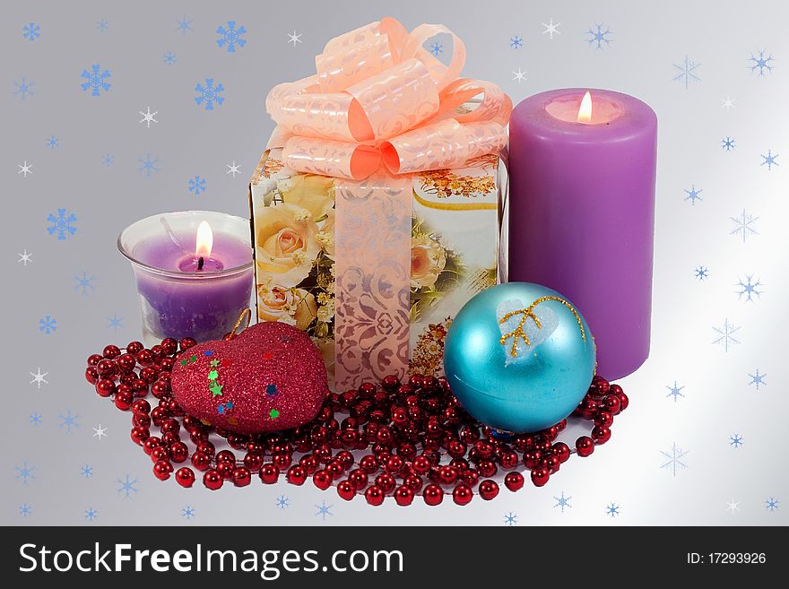 Gift and Christmas decorations, surrounded by snowflakes on a gray background. Gift and Christmas decorations, surrounded by snowflakes on a gray background