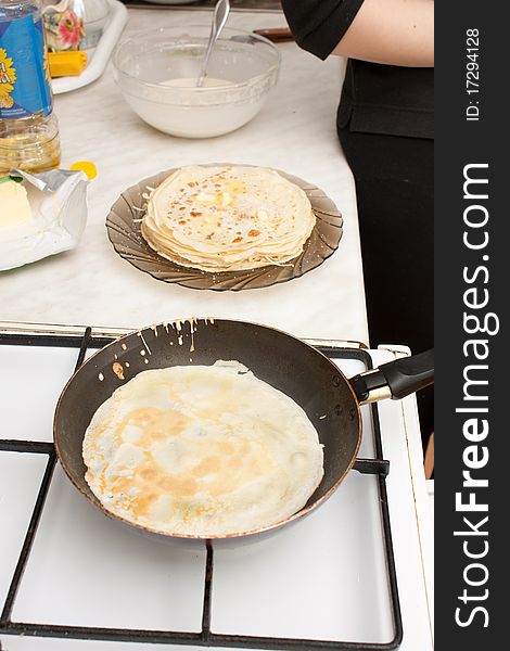 Preparation of traditional Russian pancakes by the girl in the dark