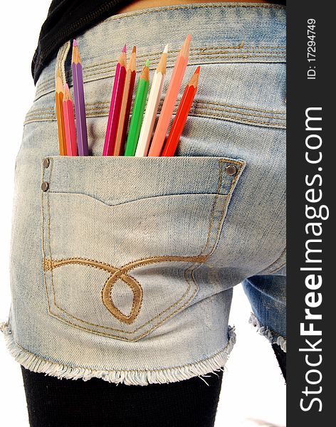 A girl with a set of colored pencils in the pocket of Jeans. A girl with a set of colored pencils in the pocket of Jeans