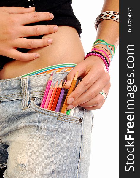 A girl with a set of colored pencils in the pocket of Jeans. A girl with a set of colored pencils in the pocket of Jeans