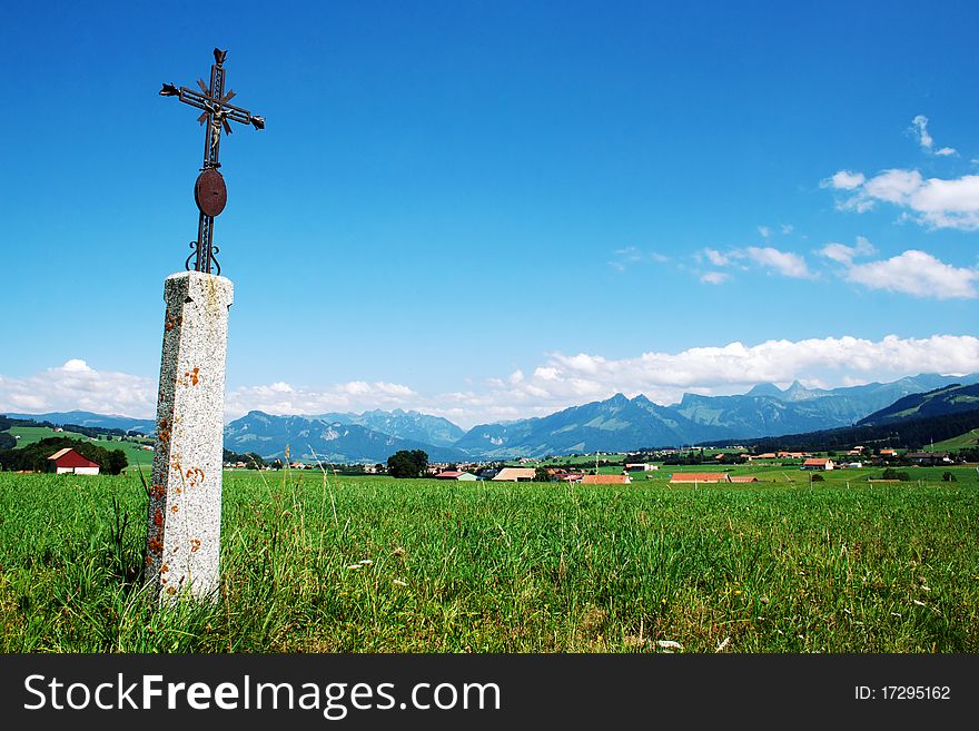 Swiss Alps landscape with a cross in a rural part of Switzerland.