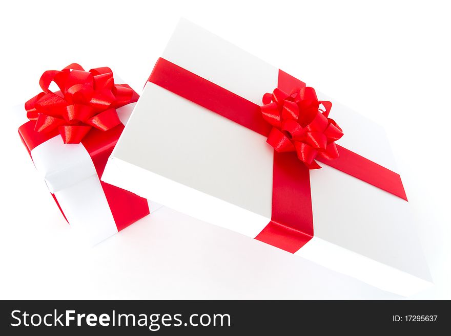 White gift boxes with red ribbon and bow isolated on white