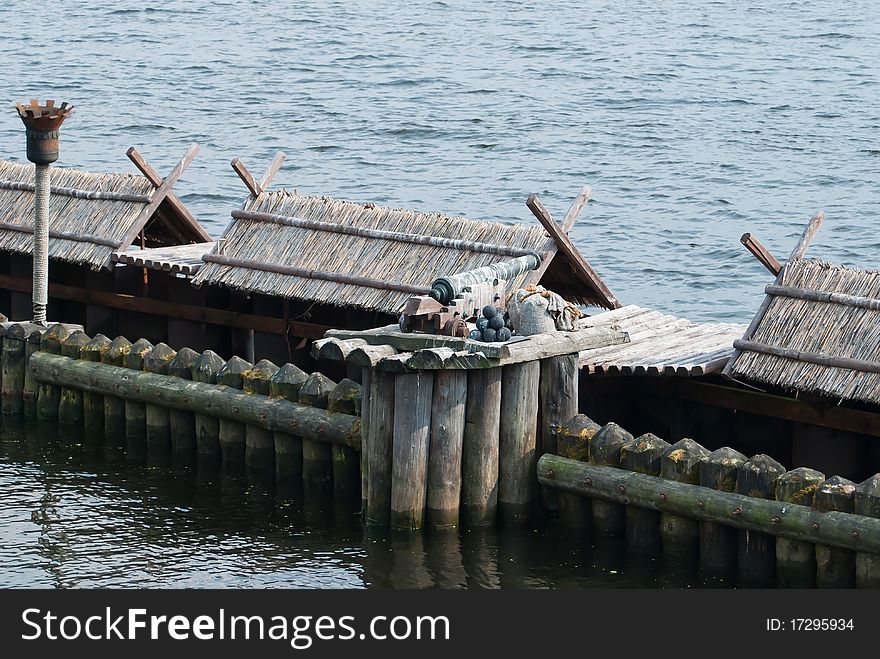 Old cannon on old wooden defenses with torches