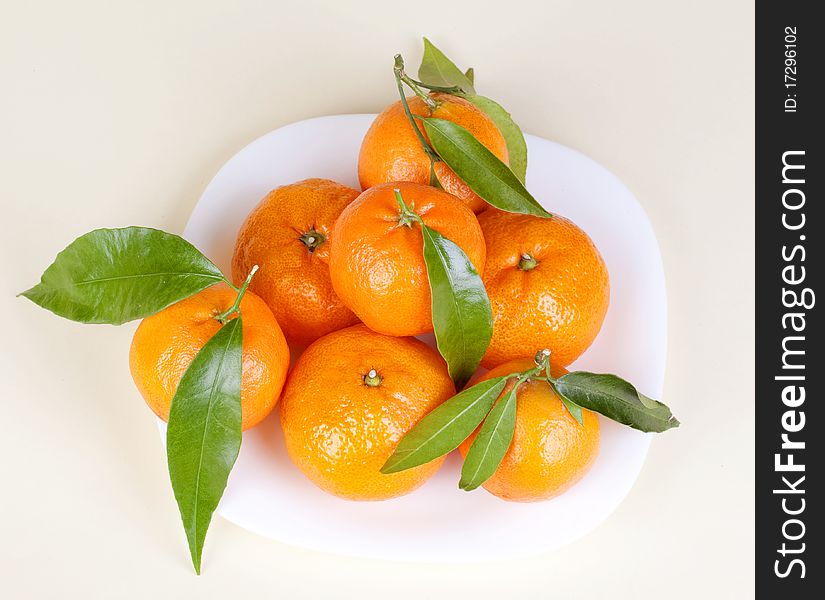 Mandarins on the plate with leafs