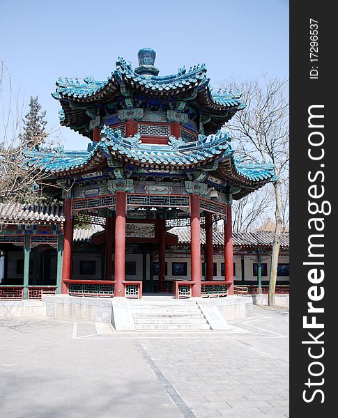 Traditional chinese ornate pavilion with tile roof and trees in early spring. In garden near Forbidden city(Beijing). Traditional chinese ornate pavilion with tile roof and trees in early spring. In garden near Forbidden city(Beijing).