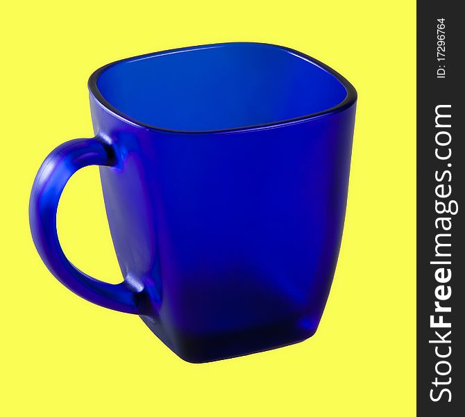 Cup from dark blue glass on a yellow background. Cup from dark blue glass on a yellow background