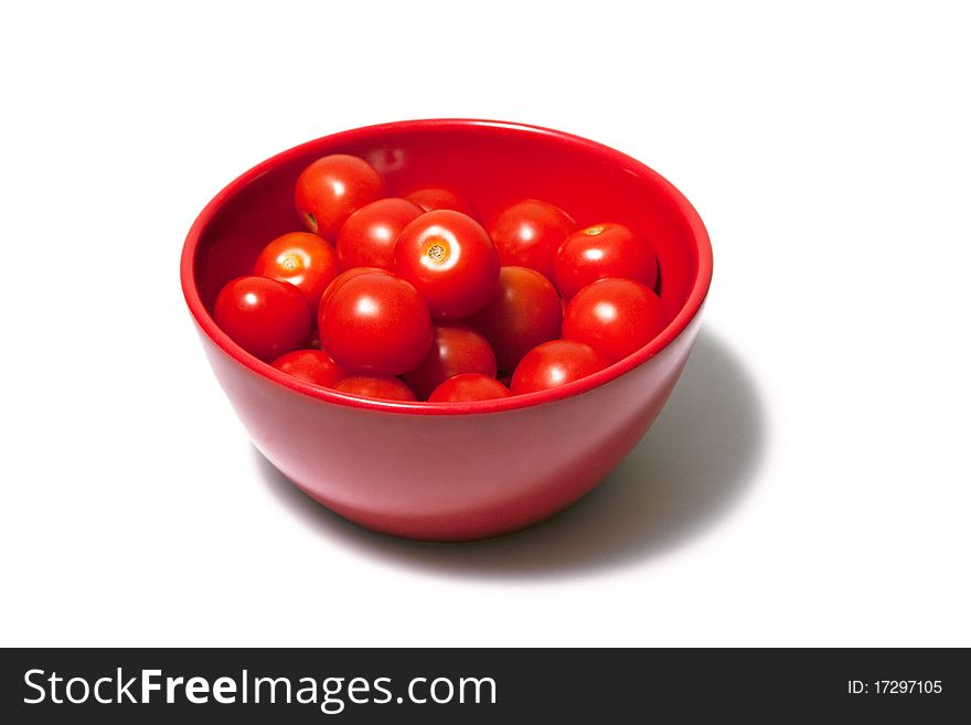 Red tomatoes in a red dish on white background