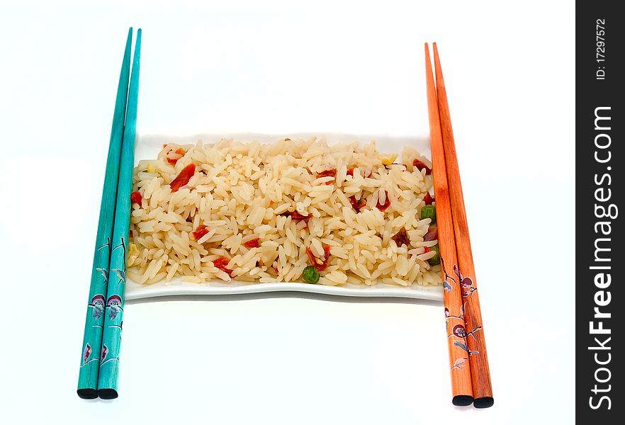 A plate of rice with vegetables and chopsticks isolated on white background. A plate of rice with vegetables and chopsticks isolated on white background