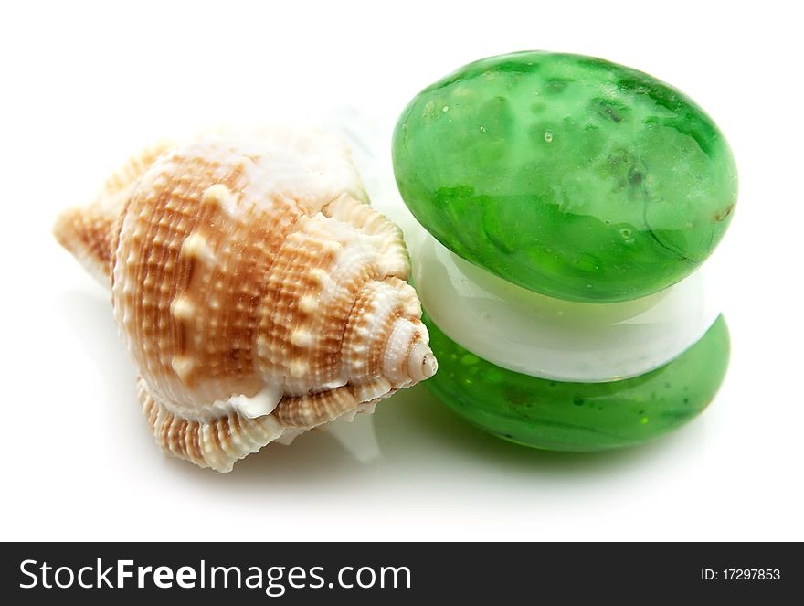 Green pebbles and sea cockleshell on a white background. Green pebbles and sea cockleshell on a white background