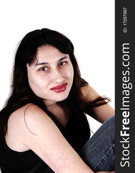 A young woman in jeans, in a closeup portrait and black blouse sitting on the floor for white background. A young woman in jeans, in a closeup portrait and black blouse sitting on the floor for white background.