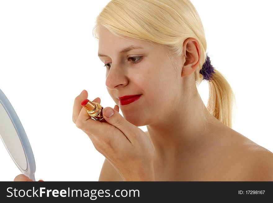A young girl is putting lipstick on. A young girl is putting lipstick on