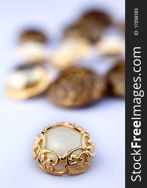 Closeup on group of vintage buttons. Focus on gold and mother-of-pearl one. Closeup on group of vintage buttons. Focus on gold and mother-of-pearl one.