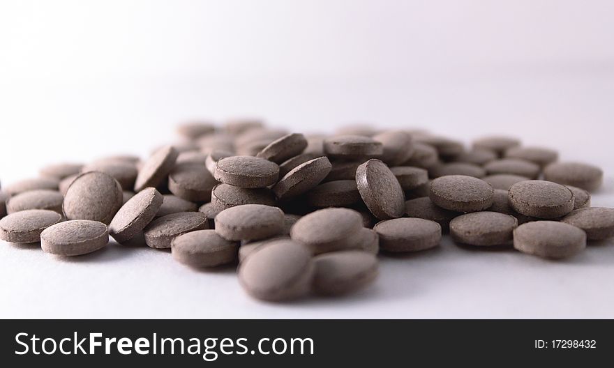 Handful of gray tablets scattered on a surface. Handful of gray tablets scattered on a surface