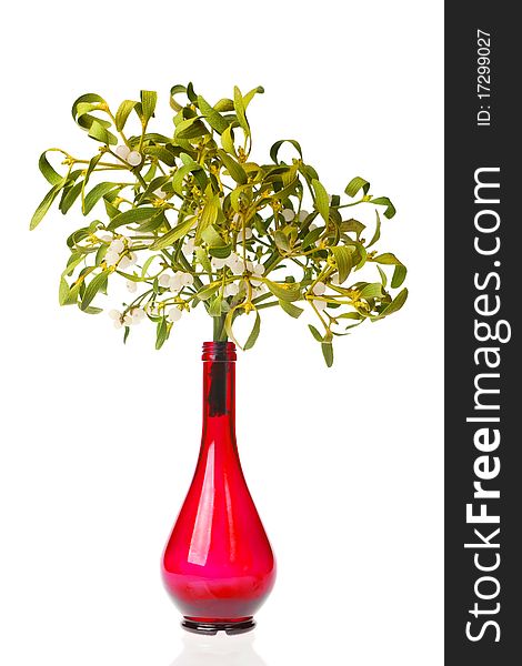 Christmas bouquet - mistletoe bunch in a red vase, isolated on white.