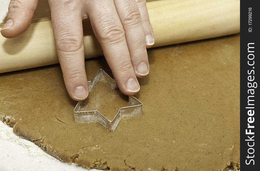 Pressing a star shape cookie cutter into cookie dough. Pressing a star shape cookie cutter into cookie dough