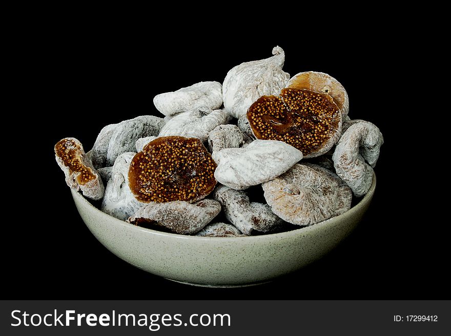 Dried figs in a ceramic bowl isolated on black