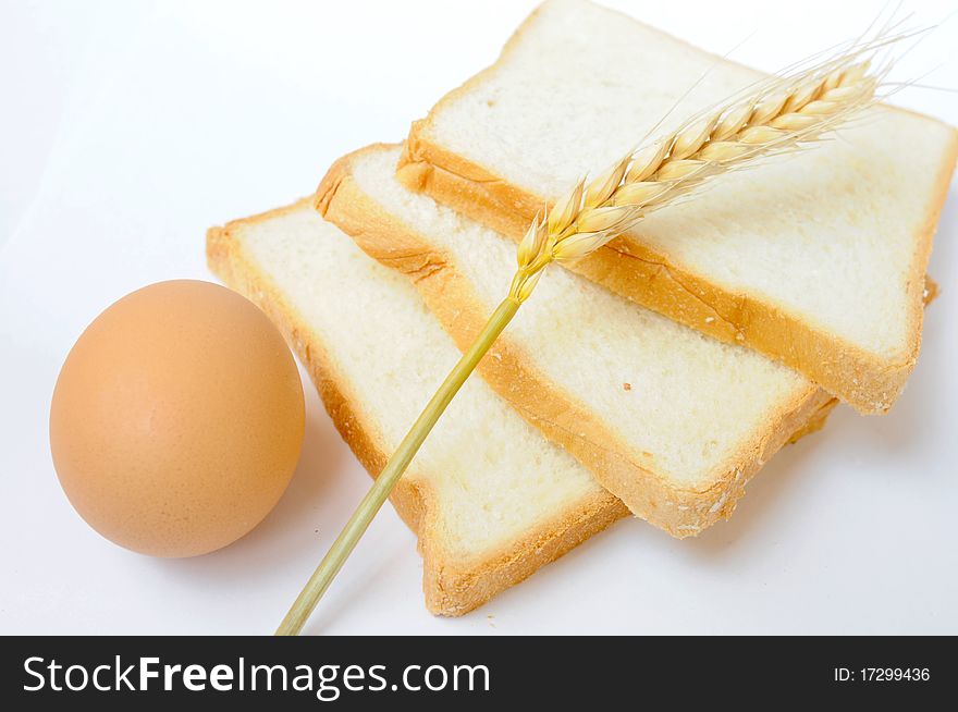 Bread,egg and wheat ear on white background