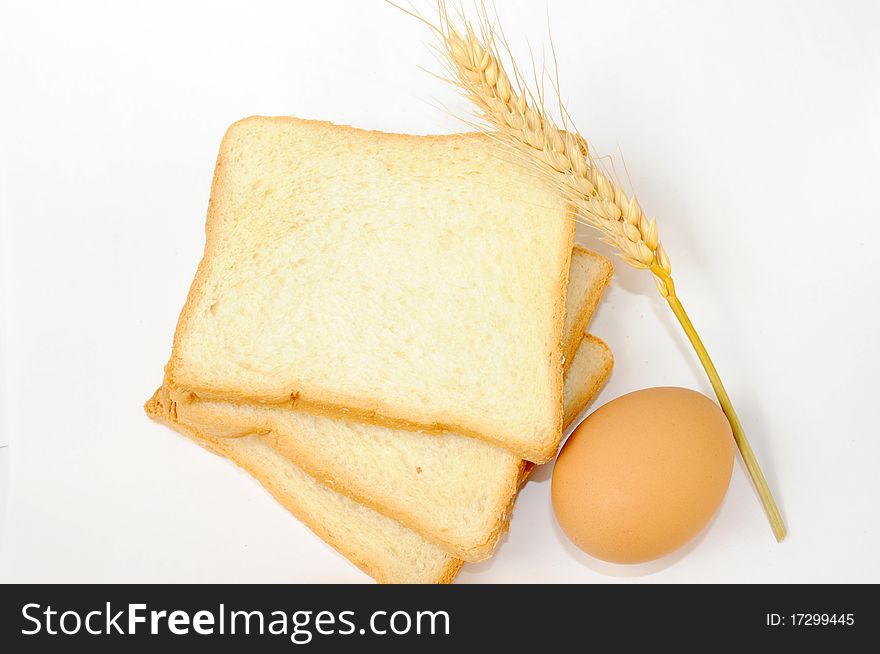 Bread,egg and wheat ear on white background