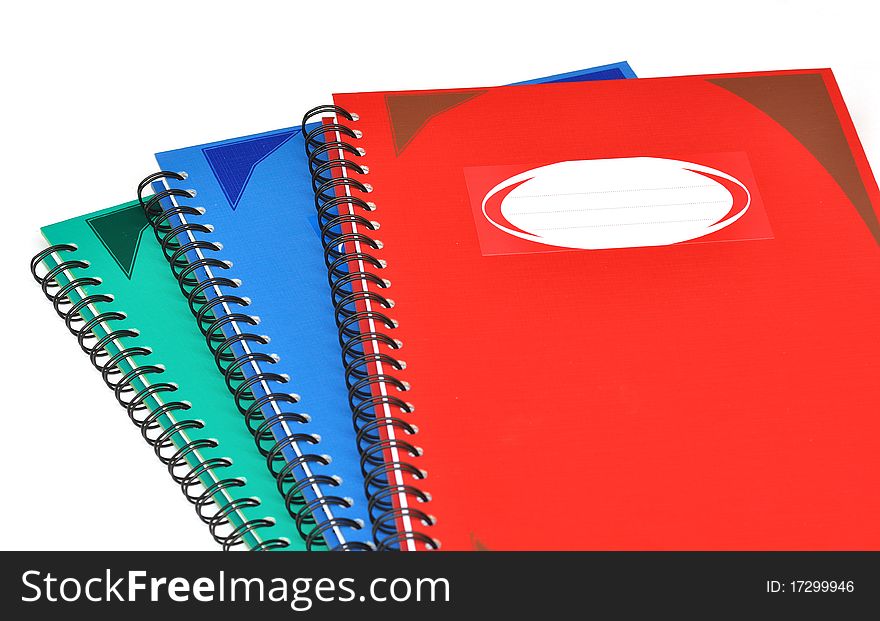 Close up of stack of three color rectangular notebooks. Close up of stack of three color rectangular notebooks.