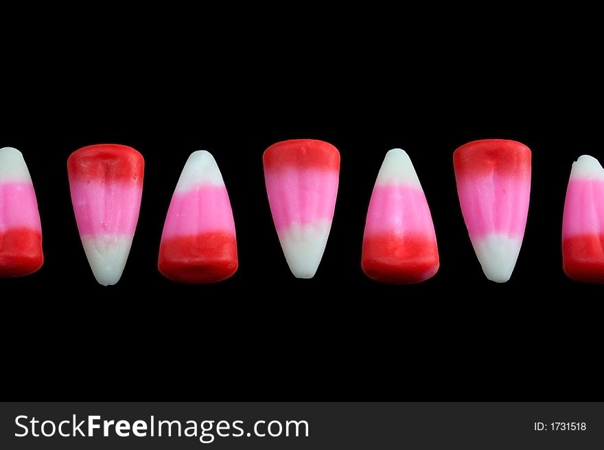 Pink candy corn line on a black background. Pink candy corn line on a black background