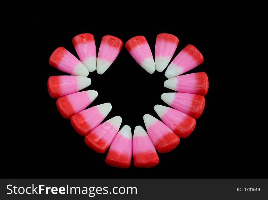 Pink candy corn heart on a black background