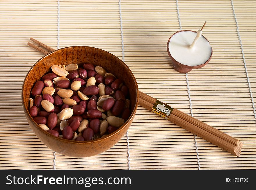 Bowl with peanut and  buddhistic candle