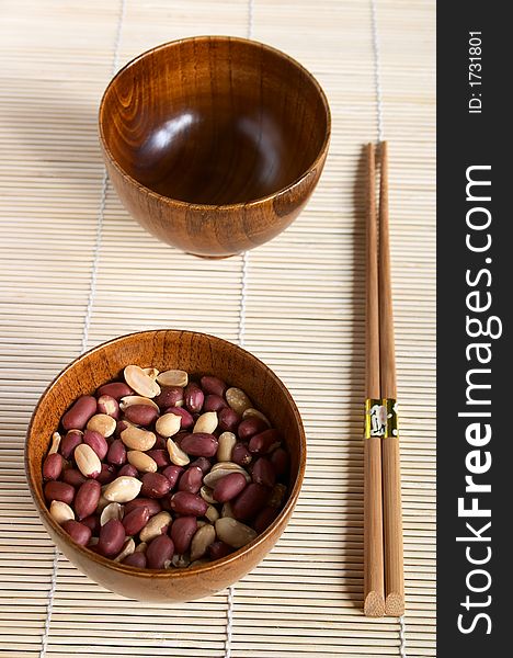 Bamboo dish with peanuts on the mat, shallow DOF