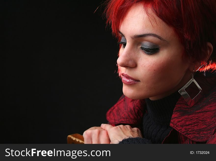 Young woman with red hair thinking, black background. Young woman with red hair thinking, black background