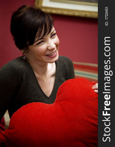 Girl holding a heart shaped pillow... valentine's day is coming soon. Girl holding a heart shaped pillow... valentine's day is coming soon