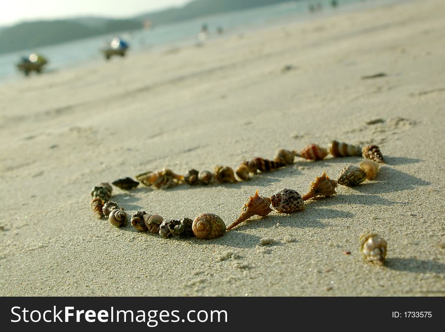 Heart from seashells on sand beach