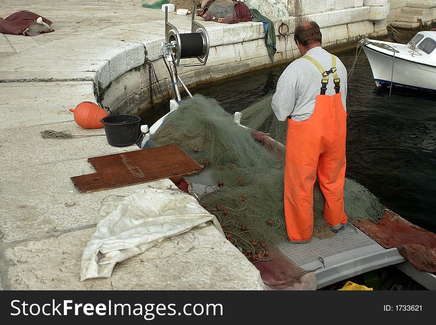 Croatian fisherman is preparing a net for fishing