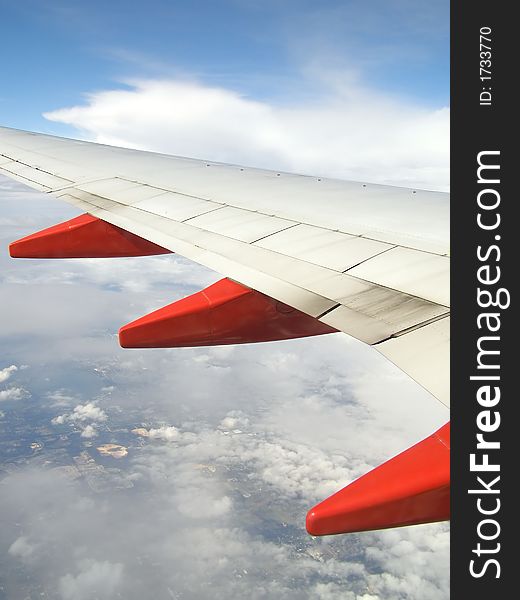 Airplane wing in flight with ground visible below. Airplane wing in flight with ground visible below