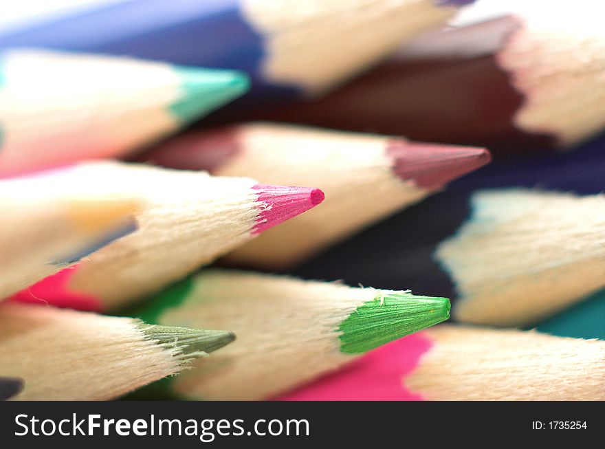 Differently coloured colouring pencils stacked together.