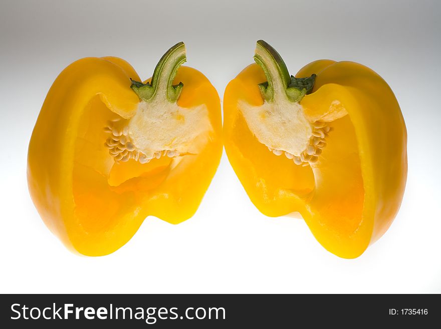 Divided Yellow Bell Pepper on a light background.