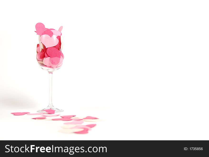 Cutout paper hearts aranged in a wine glass on a pure white background. Cutout paper hearts aranged in a wine glass on a pure white background