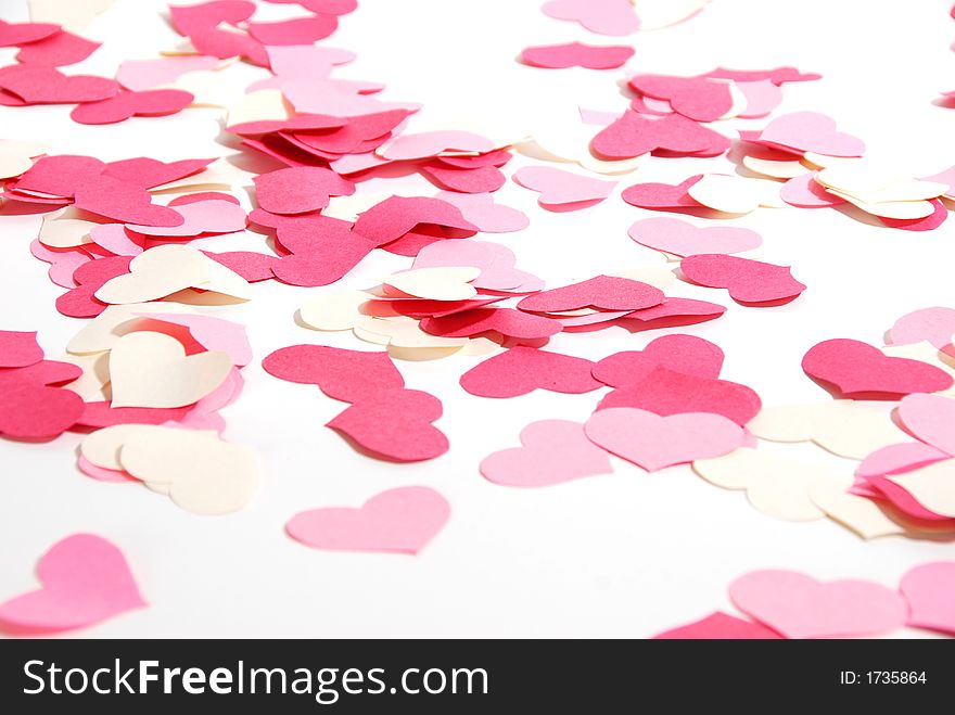 Red, pink and white paper hearts scattered on a white background. Red, pink and white paper hearts scattered on a white background