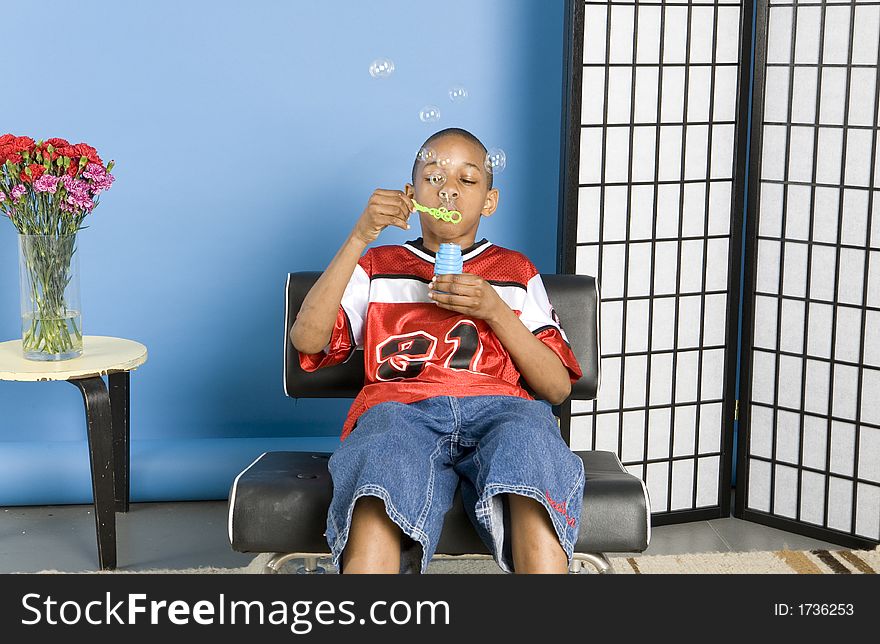 Boy blowing bubbles at home. Boy blowing bubbles at home