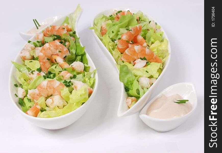 Shrimp salad in a white exclusives plates with sauce