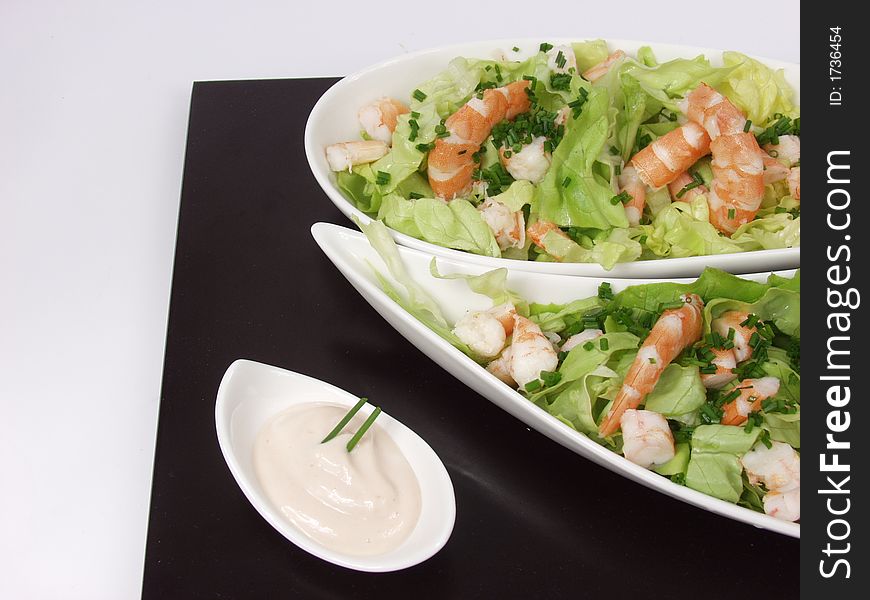 Shrimp salad in a white exclusives plates with sauce