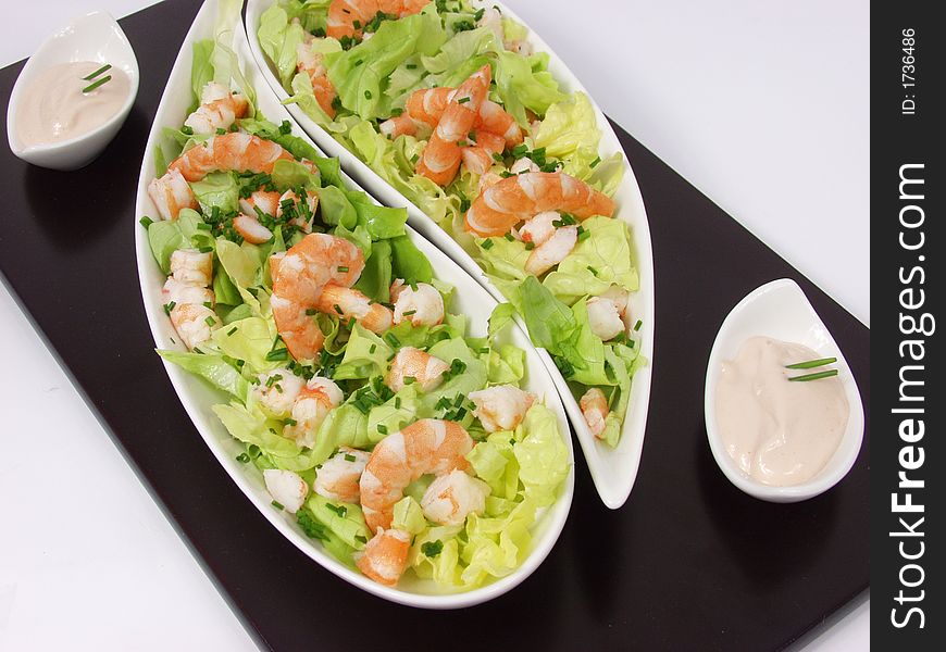 Shrimp salad in a white exclusives plates with sauce