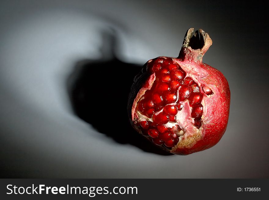 Ripe pomegranate in a ray of light