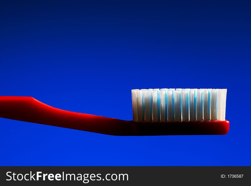 Red tooth-brush on a dark blue background