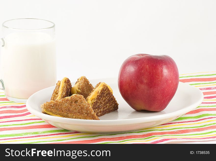 Brown bread,cheese,apple,milk and a colorful mat make a nutritious lunch or dinner special for the little ones. Brown bread,cheese,apple,milk and a colorful mat make a nutritious lunch or dinner special for the little ones.