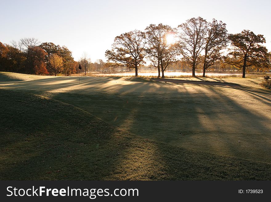 Sunsrise stretches the shadows across the green and fairway. Sunsrise stretches the shadows across the green and fairway