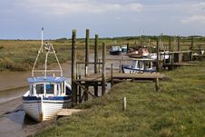Boats At Low Tide In A Channel On The Coast Royalty Free Stock Images