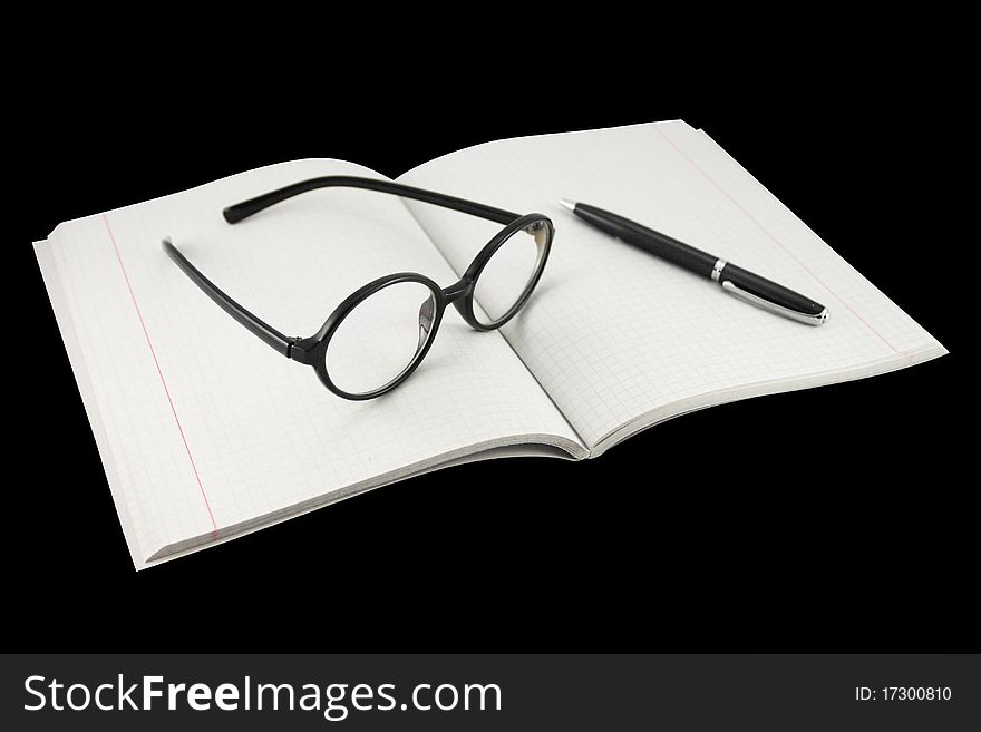 The image of spectacles under the notebook. Focus is under the central part of notebook